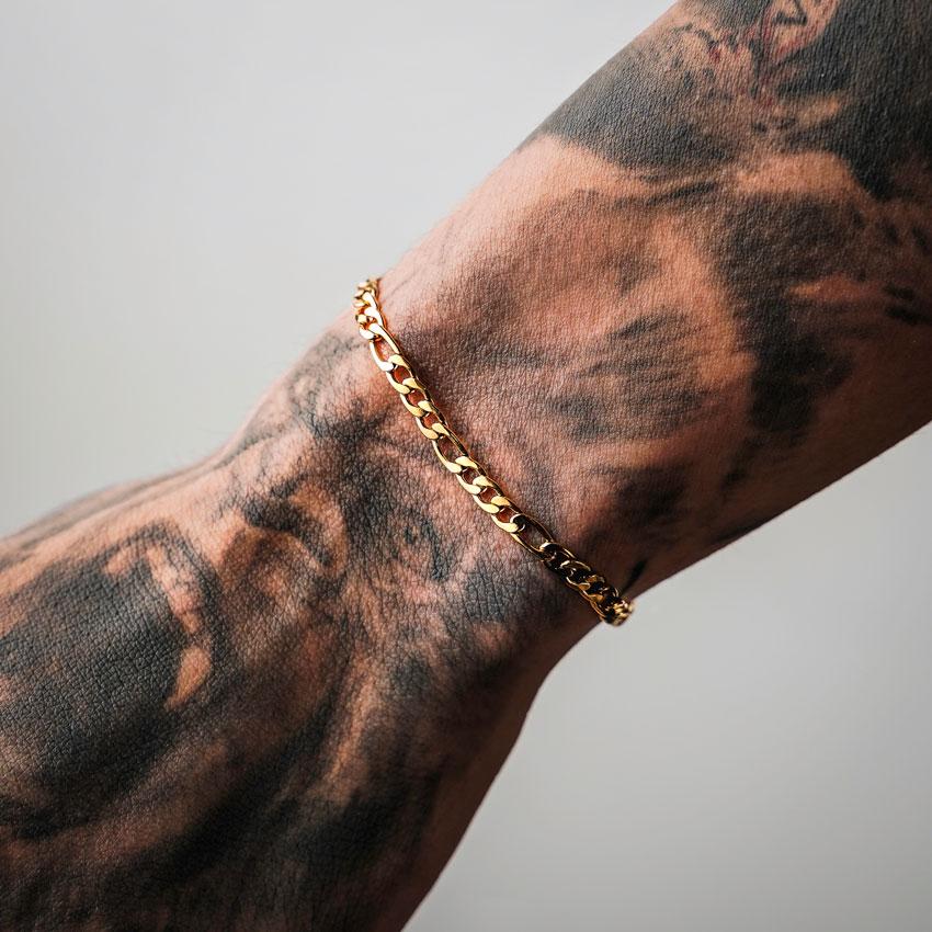 Our Gold Figaro Chain Bracelet features our premium gold figaro chain and signature polished gold plate, engraved with RG&B.